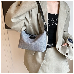 Detail of light blue hobo bag with adjustable black strap and textured fabric surface