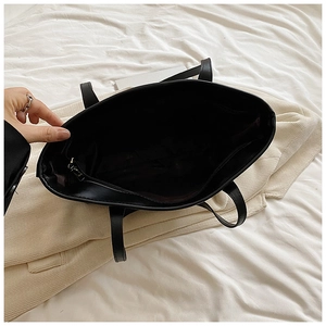 Top view of spacious interior of black faux leather tote bag with secure zipper pocket