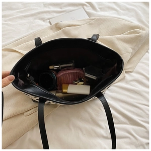 Spacious interior of a black and white cow print tote bag with organized cosmetics
