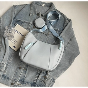 Detail of light blue hobo bag with pleated texture and detachable coin purse accessory