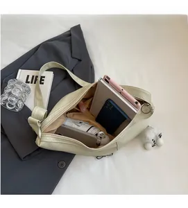Spacious interior of light green crescent bag showing tablet, phone and umbrella