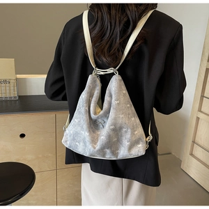 Rear view of model wearing a stylish off-white tote backpack with bow pattern and metal logo