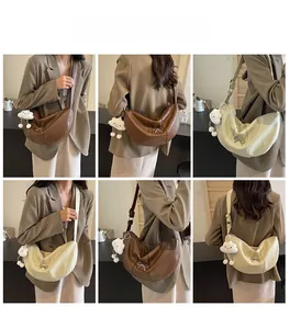 Brown and off-white half-moon crossbody bags with plush cloud charms in cafe setting