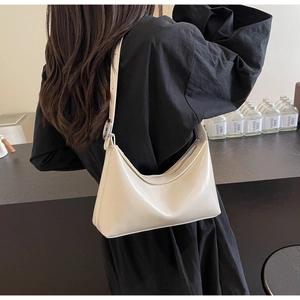 Close-up of creamy white glossy PU hobo bag with adjustable silver buckle strap
