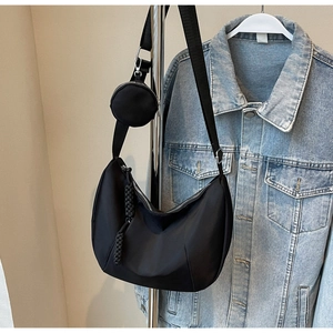 Detail of black nylon crescent moon hobo bag with detachable round coin purse and rope zipper