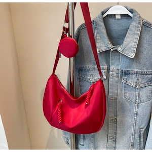 Detail of red crescent hobo bag with wide shoulder strap and round coin purse