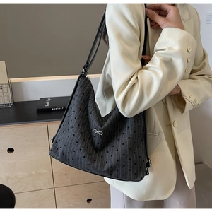 Detailed texture of dark grey tote bag with silver bow and heart stripe pattern