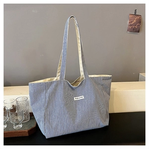 Detail of blue striped canvas tote bag showing spacious interior and side gusset design