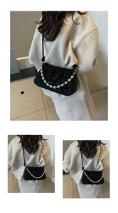 Detail der schwarzen Samt-Cloud-Bag mit dekorativer silberner Perlenkette und Riemen