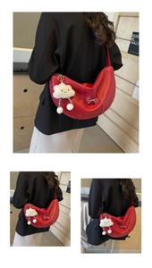 Detail of red crescent bag with lychee texture, silver bow and cloud plush charm