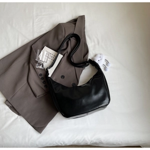 Close-up of a black crescent hobo bag with adjustable strap on white background