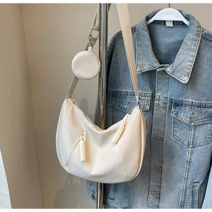 Detail of cream crescent hobo bag with woven zipper pull and small round coin purse pouch