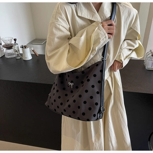 Detail of grey hobo tote with black polka dots and silver bow metal ornament