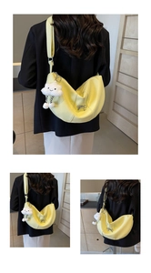 Detail of light yellow crescent bag with metallic bow and soft cloud plush charm