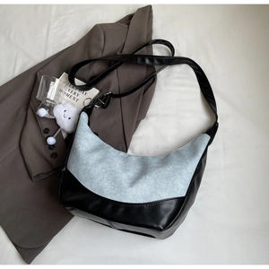 Detailed top view of light blue denim hobo bag with black leather stitching details