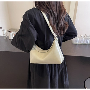 Detail of pistachio green hobo bag with adjustable strap worn on the shoulder by a model