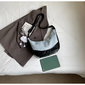 Detail of denim and leather patchwork crossbody bag with a white plush cloud charm