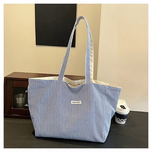 Detail of blue and white striped tote bag with Magic Pocket patch and soft texture