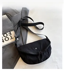 Detail view of black crescent crossbody bag with durable nylon fabric and dual zippers