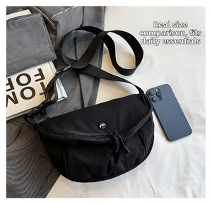 Detailed top view of a black washed fabric crossbody bag showing size with a smartphone