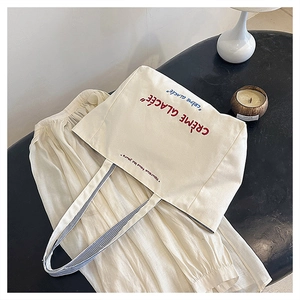 Detail of canvas tote bag with French embroidery on a minimalist table setting