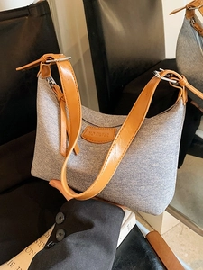 Minimalist grey denim underarm bag with brown leather strap and NO FILTER leather patch