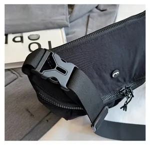Close-up of the detachable buckle and durable nylon strap on this sporty black crossbody bag