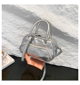 Macro view of metallic silver mini Boston bag with dual handles and KEMEROU logo