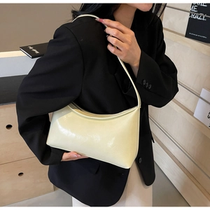 Close-up of creamy white PU leather hobo bag worn with a chic black blazer