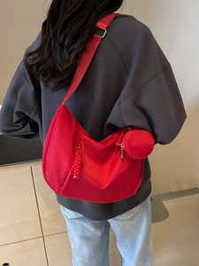 Red oversized crescent crossbody bag with small round pouch shown on model