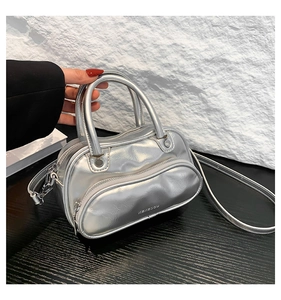Detail of silver metallic Boston bag featuring wrinkled texture and zip front pocket