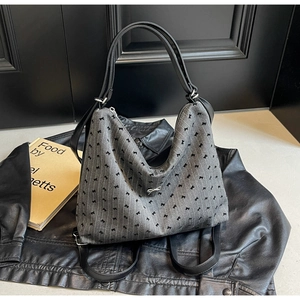 Detail of grey tote bag with embroidered bows and silver metallic bow charm detail