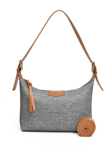 Denim shoulder bag with leather straps and an adjustable long strap on white background