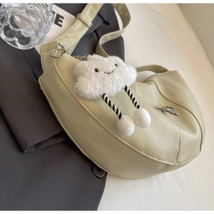 Detail of light green pebbled leather bag with a cute white plush cloud charm accessory