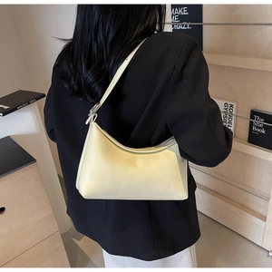 Bolso de hombro media luna amarillo pálido mostrado en un entorno minimalista
