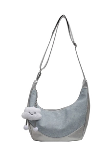 Blue denim hobo bag with silver metallic trim and cloud pendant on white background