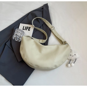 Close-up of cream crossbody bag with pebble texture and cute cloud plush charm