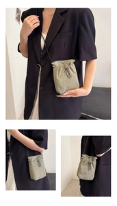 Detailed views of a mini fabric crossbody bag with drawstring closure and metal buckle