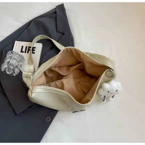 Detail view of cream dumpling bag interior with large pocket and cloud pendant
