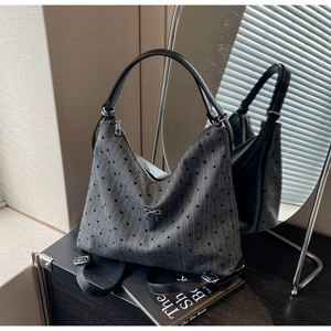 Detail of grey fabric tote with heart patterns and metal bow buckle decoration
