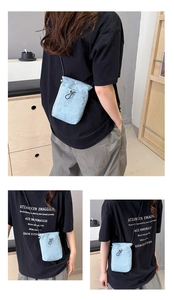 Detailed close-up of sky blue lightweight crossbody phone bag with drawstring buckle