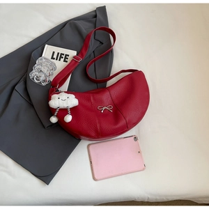 Macro shot of red faux leather dumpling bag with silver bow and cloud charm