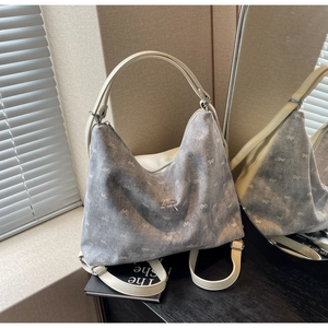 Detail of light blue denim tote bag with white bow prints and silver bow metal buckle