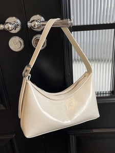 Bolso de hombro crema tipo media luna en cuero brillante con herrajes plateados
