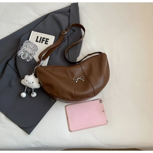 Detailed macro view of the brown lychee textured half-moon bag with bow and cloud charm
