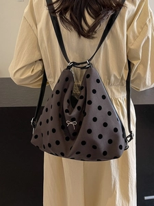 Women's brown polka dot tote backpack with a silver bow accent for casual commuting