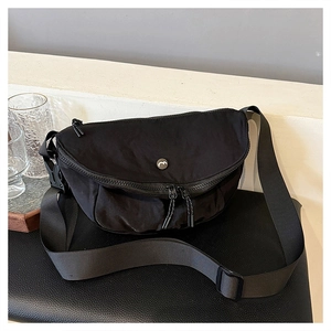 Detail of black crescent crossbody bag in waterproof nylon fabric with adjustable strap