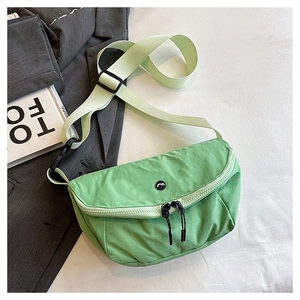 Close-up of light green nylon saddle bag with adjustable strap and dual zippers