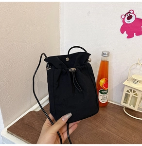 Close-up of black canvas bucket bag with drawstring closure and silver metal eyelets details