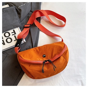 Detail of caramel orange nylon saddle bag with dual zippers and wide adjustable strap